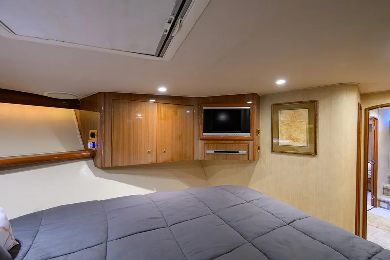  Yacht Photos Pics Luxurious cabin interior of 2008 Viking 56 Enclosed Bridge yacht with TV and wood paneling.