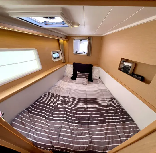 Celestra Yacht Photos Pics Cozy cabin interior of 2017 Lagoon 400 S2 catamaran with striped bedding and porthole windows.