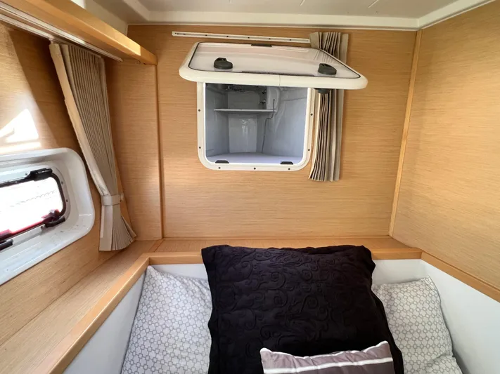 Celestra Yacht Photos Pics Cozy cabin interior of 2017 Lagoon 400 S2 catamaran with bedding and porthole.