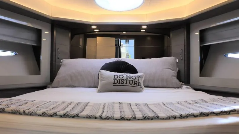  Yacht Photos Pics Luxurious bedroom interior of 2025 Cobrey 52 HT yacht with "Do Not Disturb" pillow.