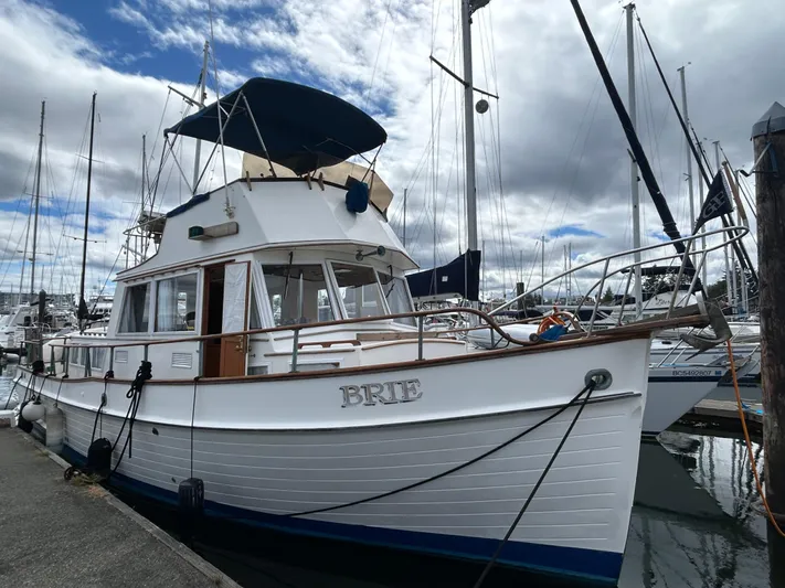 Brie Yacht Photos Pics 1980 Grand Banks 36 Classic yacht docked at marina under cloudy sky.