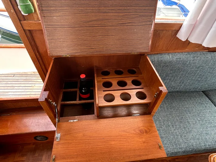 Brie Yacht Photos Pics Wooden storage compartment on 1980 Grand Banks 36 Classic boat, featuring bottle holders and seating.