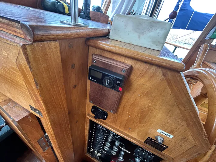 Brie Yacht Photos Pics Wooden helm station of a 1980 Grand Banks 36 Classic boat, featuring control panel and steering wheel.