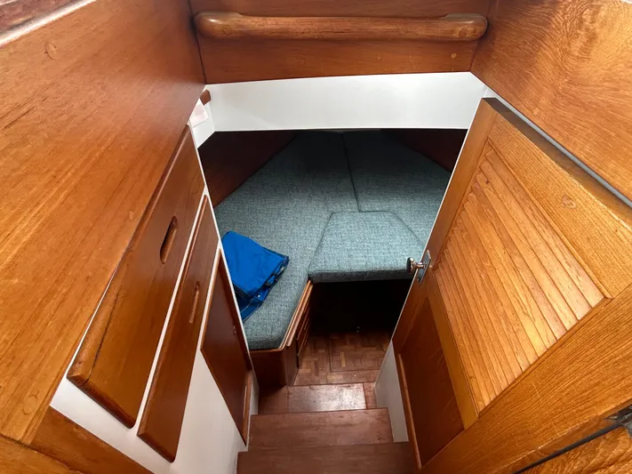 Brie Yacht Photos Pics Cozy cabin interior of 1980 Grand Banks 36 Classic with wooden finish and blue bedding.