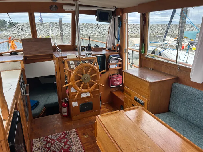 Brie Yacht Photos Pics 1980 Grand Banks 36 Classic boat interior with wooden helm, seating, and nautical equipment.