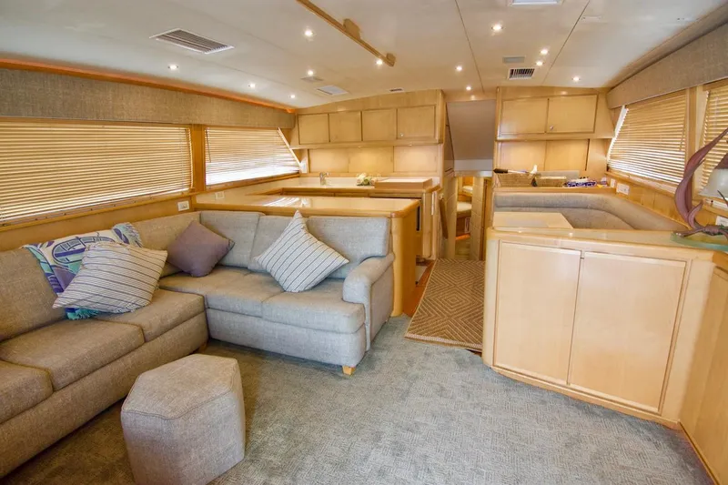 Tres Juanes Yacht Photos Pics Luxurious interior of a 1997 Bertram 54 Convertible yacht with plush seating and elegant wood finishes.