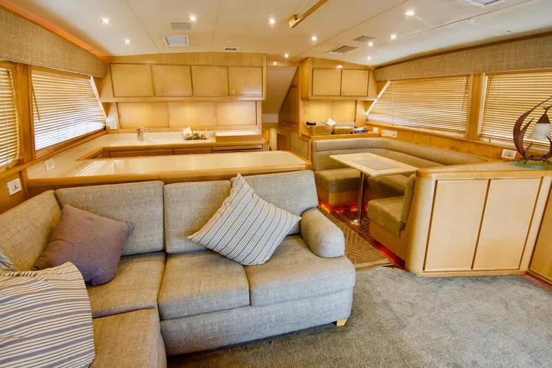 Tres Juanes Yacht Photos Pics Luxurious interior of a 1997 Bertram 54 Convertible yacht with cozy seating and elegant wood finishes.