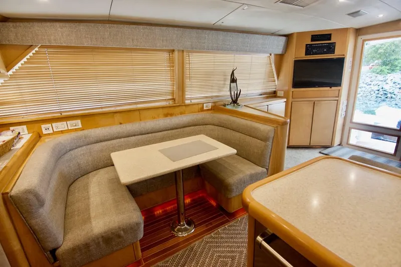 Tres Juanes Yacht Photos Pics Interior of 1997 Bertram 54 Convertible yacht with cozy dining area and modern decor.