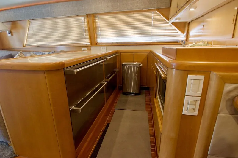 Tres Juanes Yacht Photos Pics Interior of 1997 Bertram 54 Convertible yacht kitchen with wooden cabinetry and modern appliances.