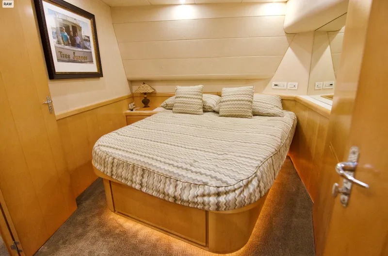Tres Juanes Yacht Photos Pics Luxurious bedroom interior of a 1997 Bertram 54 Convertible yacht with cozy bedding.