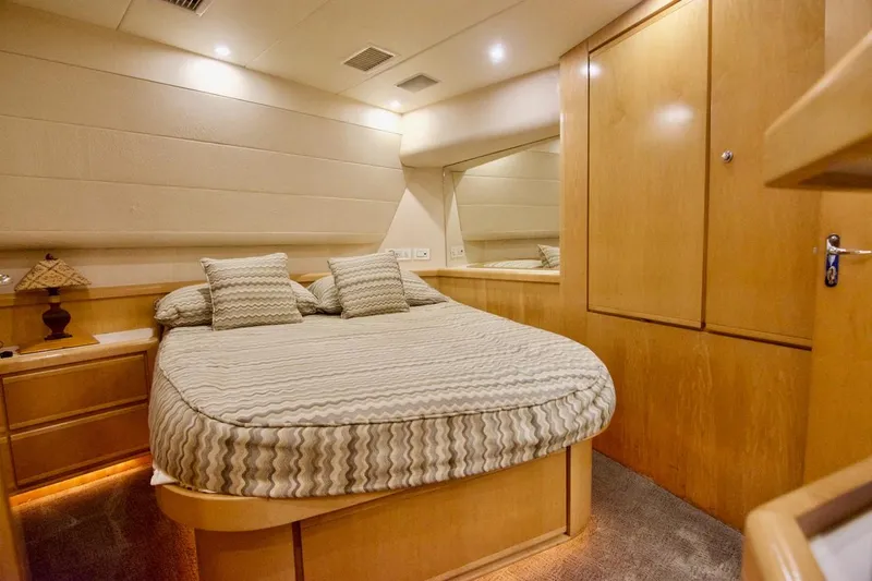 Tres Juanes Yacht Photos Pics Luxurious cabin interior of a 1997 Bertram 54 Convertible yacht with cozy bedding.