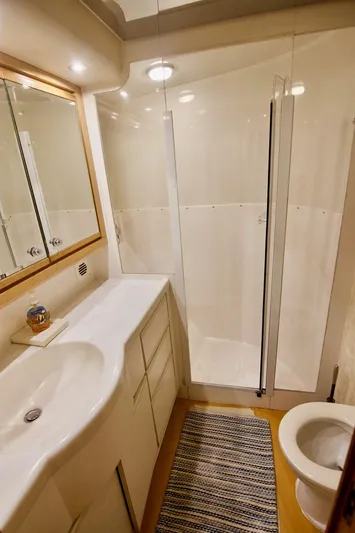 Tres Juanes Yacht Photos Pics 1997 Bertram 54 Convertible yacht bathroom with shower, vanity, and toilet.