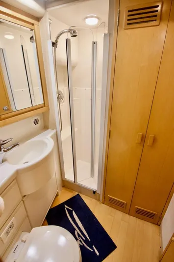 Tres Juanes Yacht Photos Pics Bathroom interior of a 1997 Bertram 54 Convertible yacht, featuring a shower and sink.