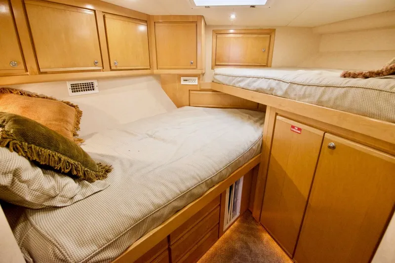 Tres Juanes Yacht Photos Pics Interior cabin of 1997 Bertram 54 Convertible yacht with wooden bunk beds.