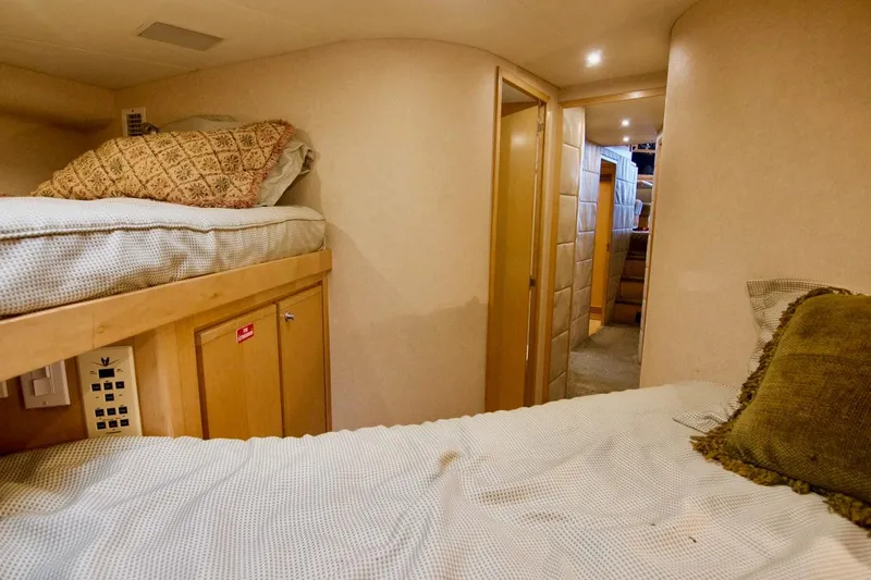 Tres Juanes Yacht Photos Pics Interior of 1997 Bertram 54 Convertible yacht with cozy bunk beds and warm lighting.