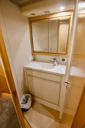 Tres Juanes Yacht Photos Pics Bathroom interior of a 1997 Bertram 54 Convertible yacht, featuring a sink and mirror.