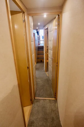 Tres Juanes Yacht Photos Pics Hallway inside 1997 Bertram 54 Convertible yacht with carpet and wooden doors.