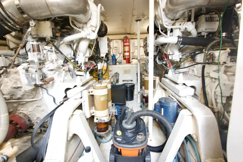 Tres Juanes Yacht Photos Pics Engine room of a 1997 Bertram 54 Convertible yacht, showcasing machinery and equipment.