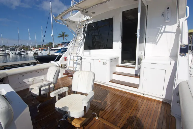 Tres Juanes Yacht Photos Pics 1997 Bertram 54 Convertible yacht deck with seating, docked at marina.