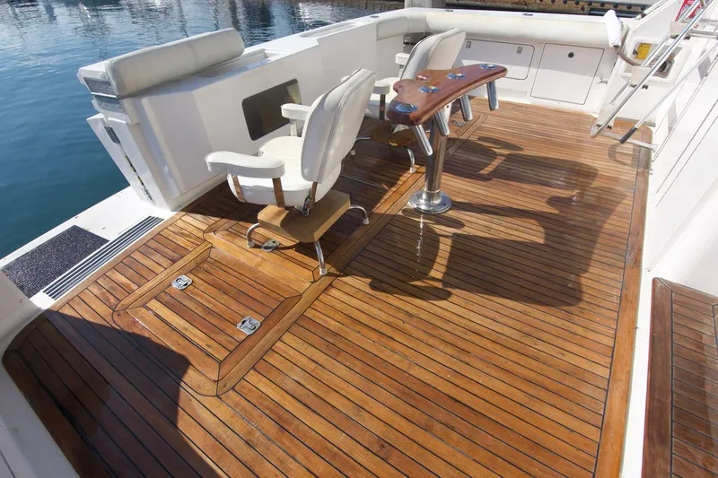 Tres Juanes Yacht Photos Pics Bertram 54 Convertible 1997 yacht deck with wooden flooring and seating.
