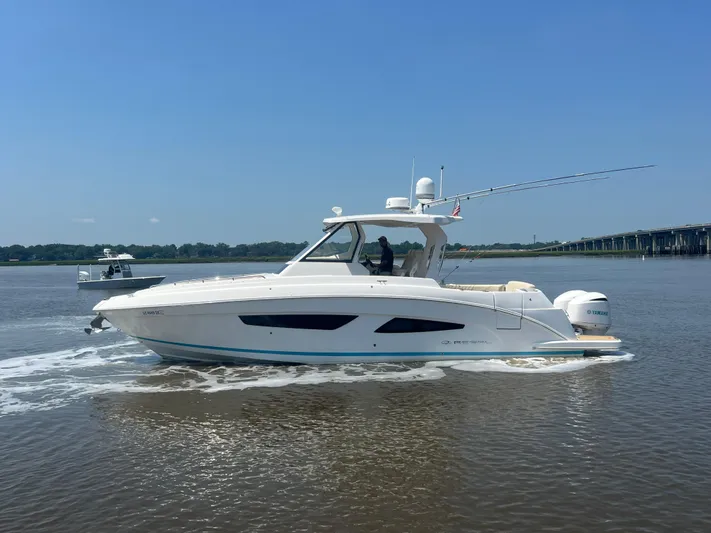  Yacht Photos Pics 2019 Regal 33 SAV boat cruising on a calm river under a clear blue sky.