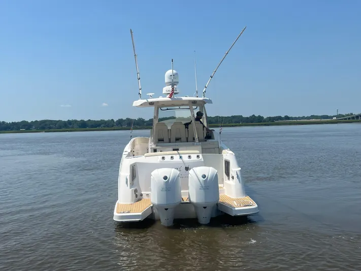  Yacht Photos Pics 2019 Regal 33 SAV boat on calm water, rear view with dual engines.