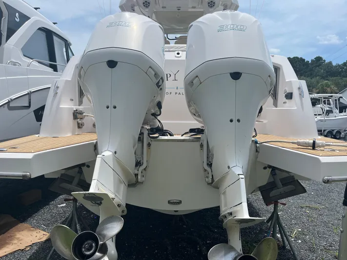  Yacht Photos Pics 2019 Regal 33 SAV boat with dual outboard engines, docked on a sunny day.