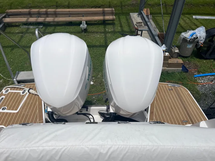  Yacht Photos Pics 2019 Regal 33 SAV boat with dual outboard engines on a wooden deck.