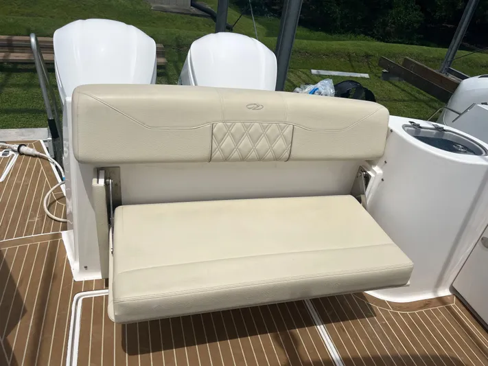  Yacht Photos Pics 2019 Regal 33 SAV boat seat with white upholstery and teak flooring.