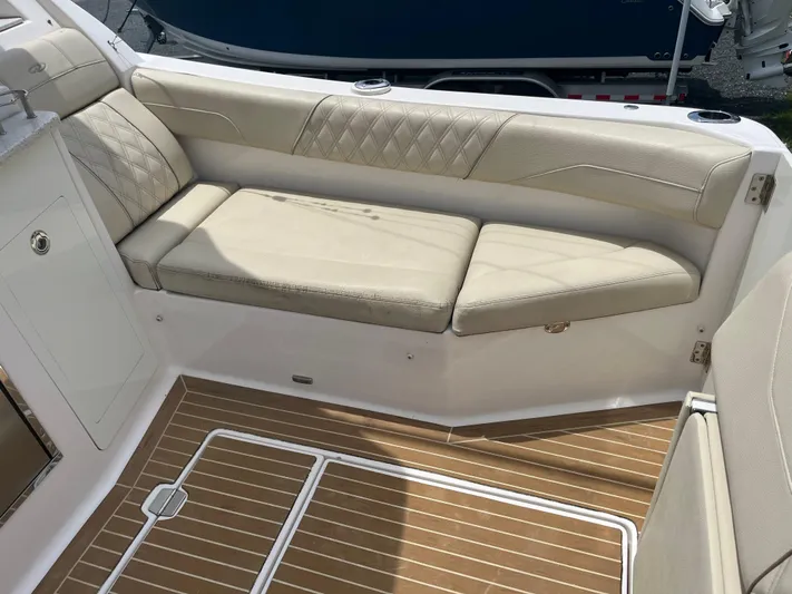 Yacht Photos Pics Luxurious seating area on 2019 Regal 33 SAV boat with beige cushions and wood flooring.