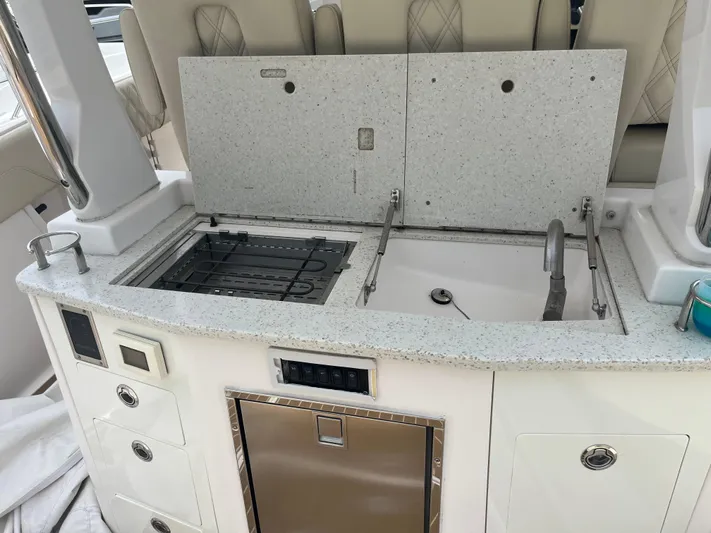  Yacht Photos Pics 2019 Regal 33 SAV boat kitchenette with sink, stove, and storage compartments.