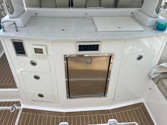  Yacht Photos Pics 2019 Regal 33 SAV boat kitchenette with sink, storage, and stainless steel fridge.
