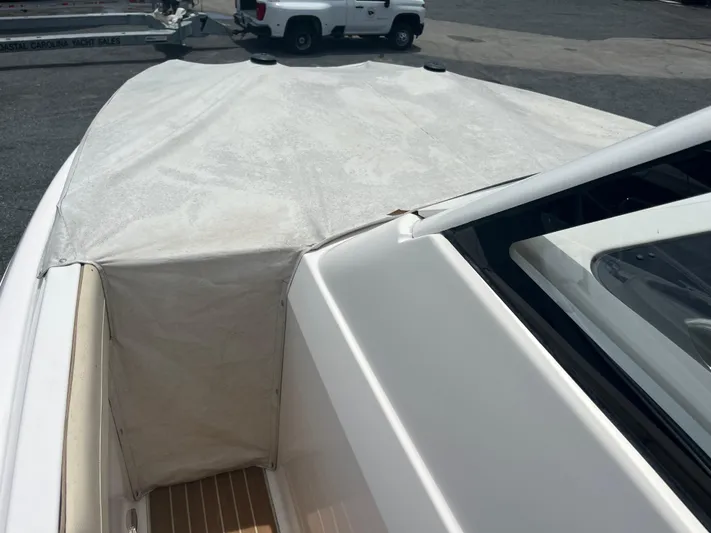  Yacht Photos Pics 2019 Regal 33 SAV boat with covered bow, parked near a trailer and vehicle.