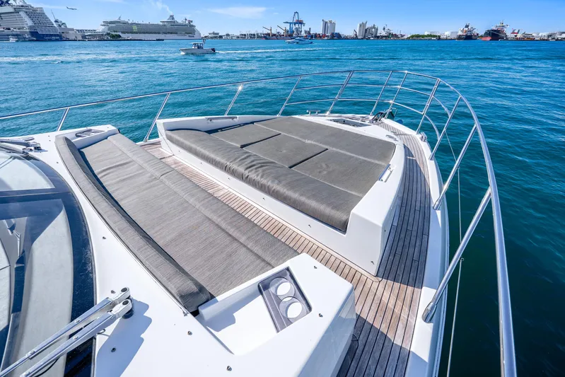 Azure Yacht Photos Pics Luxurious 2021 Azimut S6 yacht deck with sun loungers, overlooking a vibrant harbor.