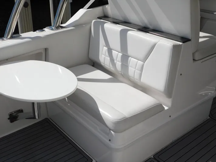 Out To Lunch Yacht Photos Pics 2019 Everglades 340 DC boat seating area with white cushioned seats and a small table.