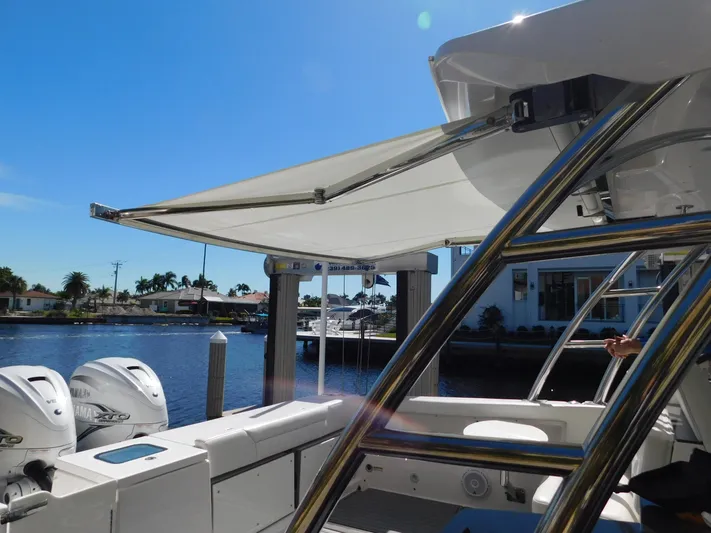 Out To Lunch Yacht Photos Pics 2019 Everglades 340 DC boat with extended sunshade, docked by waterfront homes.