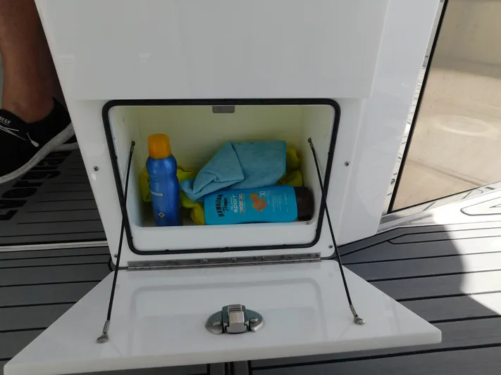 Out To Lunch Yacht Photos Pics Storage compartment on 2019 Everglades 340 DC boat with sunscreen and cleaning supplies.