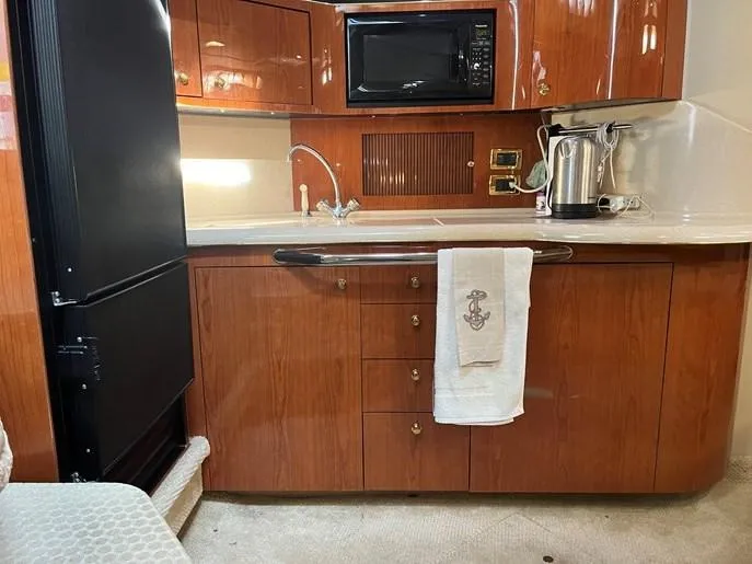  Yacht Photos Pics 2001 Sea Ray 380 Sundancer kitchen with wood cabinets, microwave, and towel.