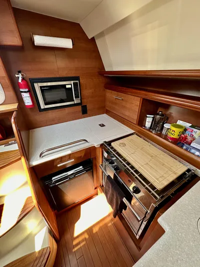 Wind Hunter Yacht Photos Pics 2013 Hunter 33 yacht kitchen with modern appliances and wooden cabinetry.