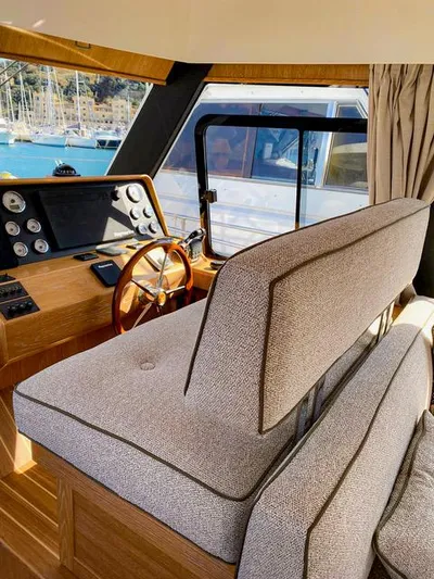  Yacht Photos Pics Interior of 2019 Sasga Yachts Menorquin 54 with helm, wooden dashboard, and plush seating.