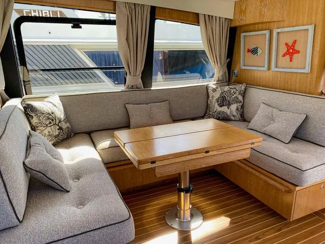  Yacht Photos Pics Interior of 2019 Sasga Yachts Menorquin 54 with cozy seating and wooden table.