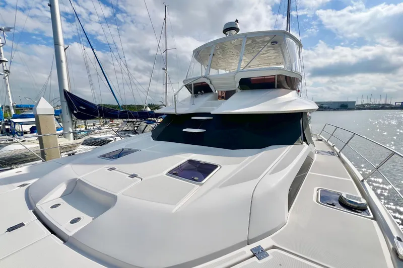 Tonga Time Yacht Photos Pics 2019 Aquila 44 yacht docked at marina under a partly cloudy sky.
