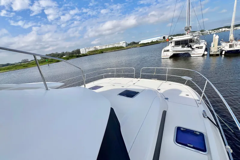 Tonga Time Yacht Photos Pics 2019 Aquila 44 yacht on calm water, with clear sky and marina view.