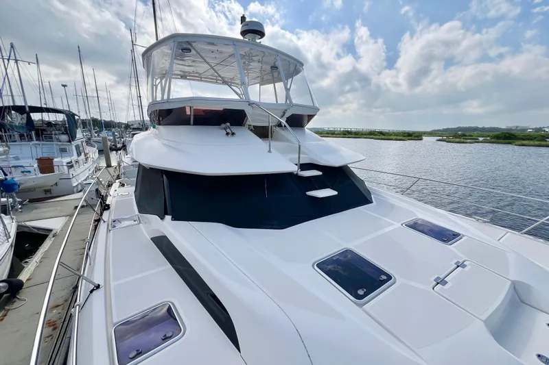 Tonga Time Yacht Photos Pics 2019 Aquila 44 yacht docked, featuring sleek design and spacious upper deck.
