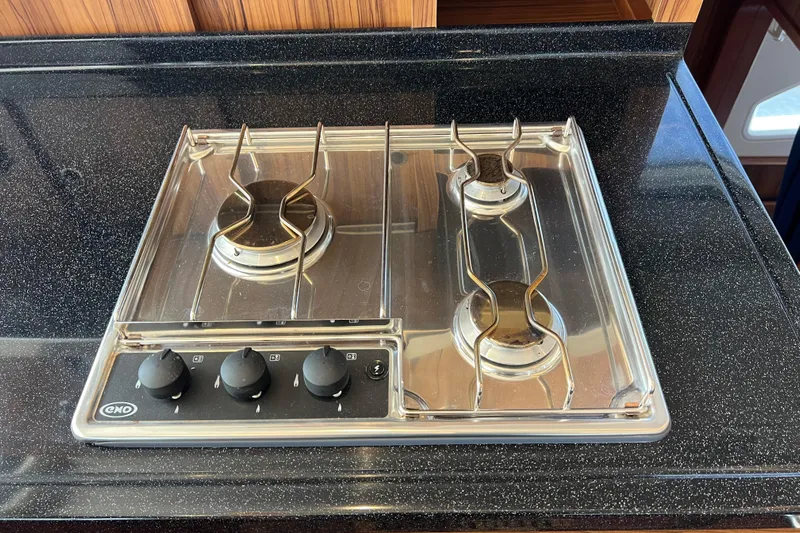 Tonga Time Yacht Photos Pics Modern gas stove with three burners on a sleek black countertop, Aquila 44, 2019 model.