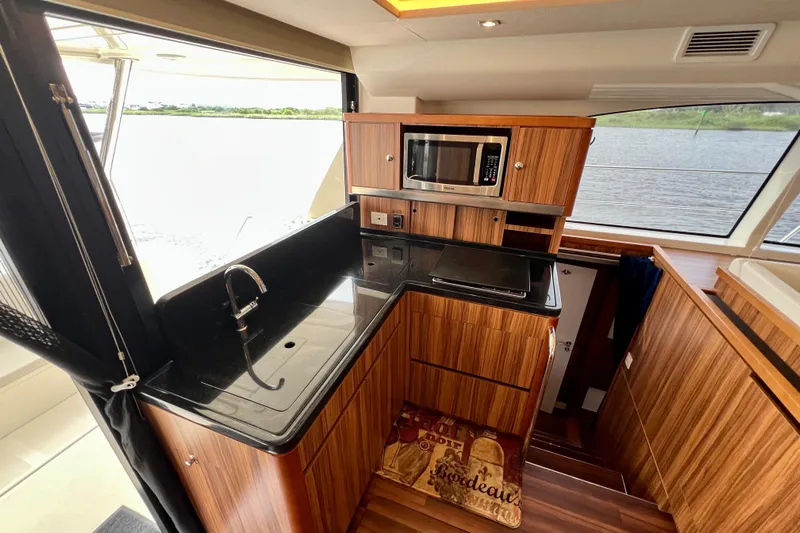 Tonga Time Yacht Photos Pics Luxurious kitchen interior of 2019 Aquila 44 yacht with wood finish and modern appliances.