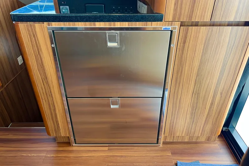 Tonga Time Yacht Photos Pics Stainless steel refrigerator in 2019 Aquila 44 yacht kitchen with wood paneling.