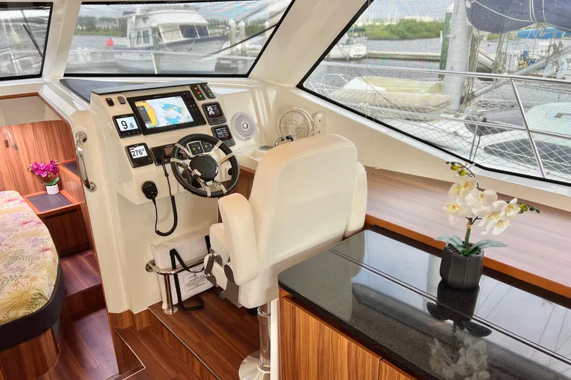 Tonga Time Yacht Photos Pics Luxurious 2019 Aquila 44 yacht interior with modern helm, floral decor, and panoramic windows.
