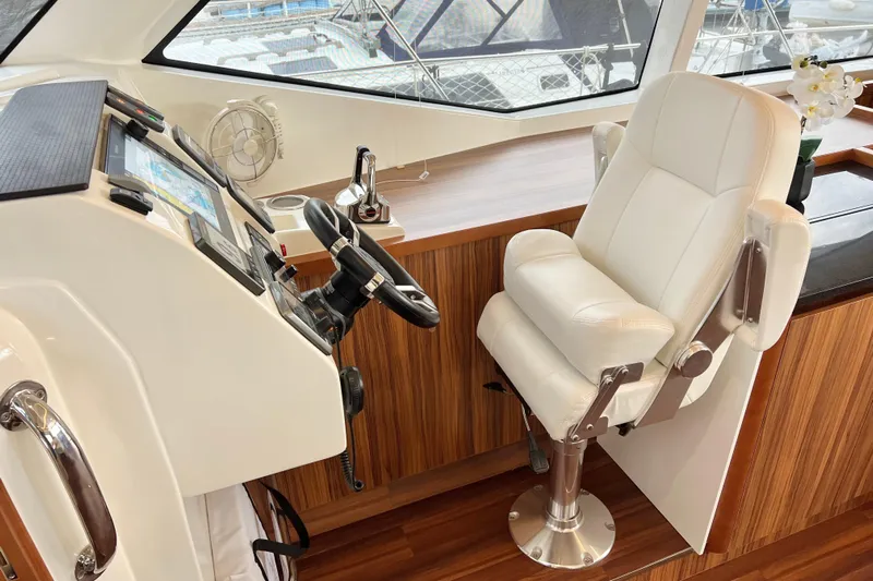 Tonga Time Yacht Photos Pics Helm station of 2019 Aquila 44 yacht with white captain's chair and navigation controls.
