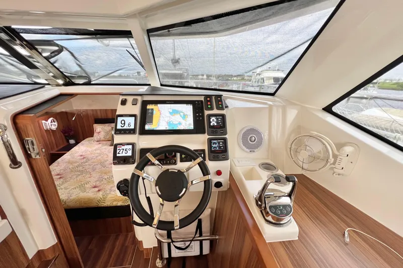 Tonga Time Yacht Photos Pics 2019 Aquila 44 yacht helm with navigation controls, steering wheel, and cabin view.